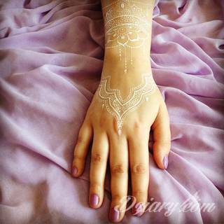 Białe tatuaże wyglądające np. na dłoni niczym delikatna, koronkowa rękawiczka. Świetne wzory dla kobiet dbających o nieprzeciętny image. Białe tatuaże o różnorodnym poziomie detali pozwalają na ozdobienie skóry w sposób subtelny i ujęty w formie symbolu.