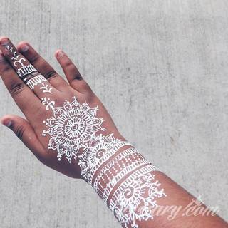 Białe tatuaże wyglądające np. na dłoni niczym delikatna, koronkowa rękawiczka. Świetne wzory dla kobiet dbających o nieprzeciętny image. Białe tatuaże o różnorodnym poziomie detali pozwalają na ozdobienie skóry w sposób subtelny i ujęty w formie symbolu.