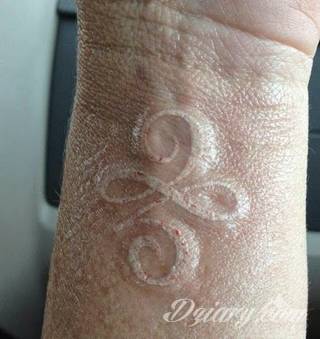 Białe tatuaże wyglądające np. na dłoni niczym delikatna, koronkowa rękawiczka. Świetne wzory dla kobiet dbających o nieprzeciętny image. Białe tatuaże o różnorodnym poziomie detali pozwalają na ozdobienie skóry w sposób subtelny i ujęty w formie symbolu.