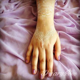 Białe tatuaże wyglądające np. na dłoni niczym delikatna, koronkowa rękawiczka. Świetne wzory dla kobiet dbających o nieprzeciętny image. Białe tatuaże o różnorodnym poziomie detali pozwalają na ozdobienie skóry w sposób subtelny i ujęty w formie symbolu.