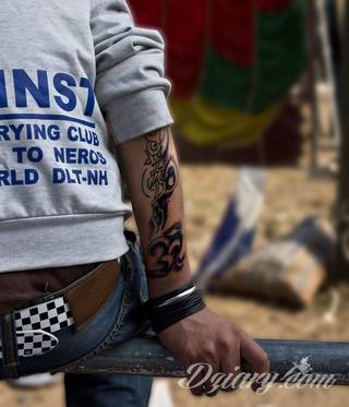 Niewielkie tatuaże na ręce. Formaty skromne i pozbawione akcentów kolorystycznych oraz rozbudowane kształty grafik, które zajmują duże fragmenty dłoni i wykorzystują palce jako np. fragmenty obrazu. 