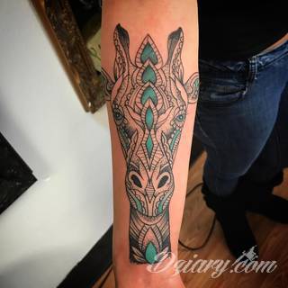 Tatuaż z żyrafą bywa absurdalny, ale właśnie na tym polega jego urok. Charakterystyka żyraf sprawia, że grafiki świetnie prezentują się na rękach czy nogach. Tatuaże często wykorzystują również naturalne elementy skóry - np. pieprzyki - do nadania żyrafie cech charakterystycznych. 