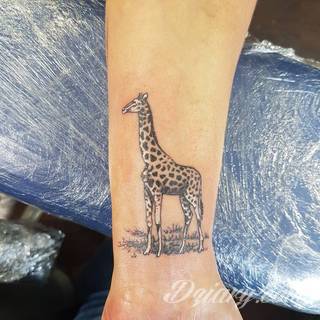Tatuaż z żyrafą bywa absurdalny, ale właśnie na tym polega jego urok. Charakterystyka żyraf sprawia, że grafiki świetnie prezentują się na rękach czy nogach. Tatuaże często wykorzystują również naturalne elementy skóry - np. pieprzyki - do nadania żyrafie cech charakterystycznych. 
