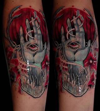 Czarno-czerwony tatuaż krwawego księżycu, ręki oraz żuchwy.