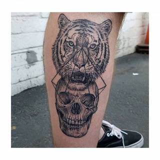 Czarnobiały tatuaż z czaszką i tygrysem.