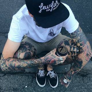 Duża ilość ciekawych tatuaży u mężczyzny. Między innymi na kolanie pajęczyna. Z innych bardziej charakterystycznych: wilk, czaszka, postać na ręce oraz kwiat.