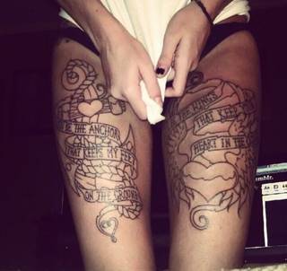 Dwa piękne tatuaże z napisami, skrzydłami i sercami na udach.