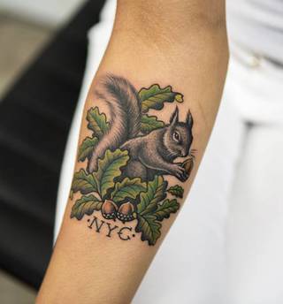 Dziara wiewiórki z orzechem na ramieniu.