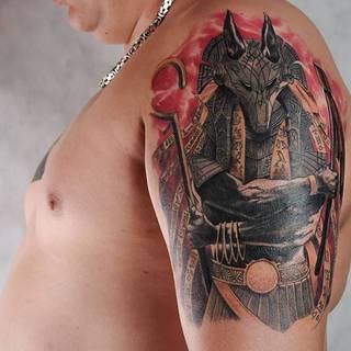 Egipski bóg Ozyrys wytatuowany na barku i ramieniu.