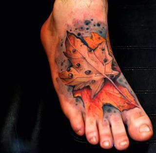 Jesienny liść wydziarany na stopie.