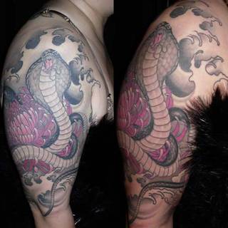 Kobra wśród kwiatów na ramieniu.