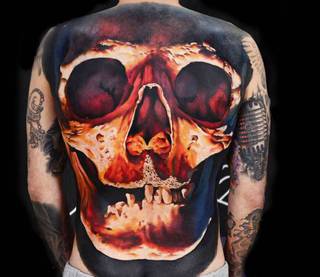 Kolorowy tatuaż czaszki na całe plecy.