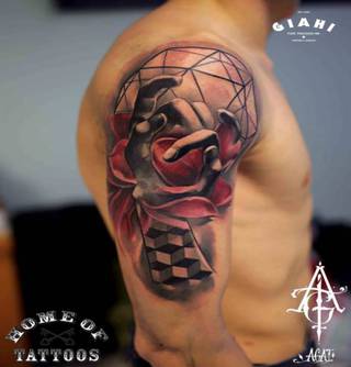 Kwiaty i geometryczne wzory z dłonią wytatuowane na ramieniu.