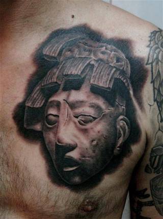 Tatuaż z antyczną statuą na klatce piersiowej.