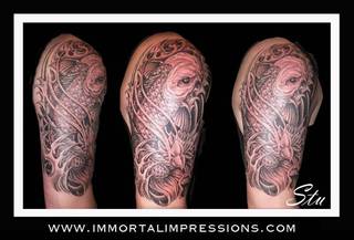 Tatuaż z motywami rybich łusek na ramieniu.