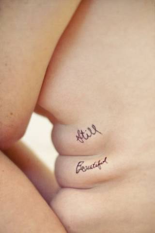 Tatuaż zrobiony na dwóch fałdkach na brzuchu z napisem "still beautiful". Przypomnienie, że pomimo niedoskonałości ciała nadal jest się pięknym.