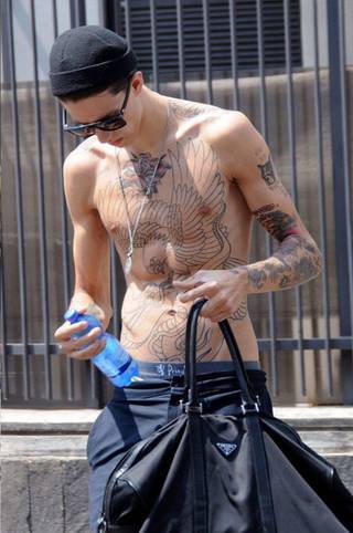 Tatuaże na klatce piersiowej (ptak, prawdopodobnie orzeł i róża) szyi oraz ręce