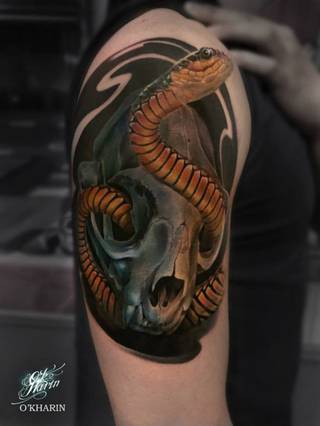 Wąż wypełzający ze starej, zwierzęcej czaszki na prawym braku i ramieniu.