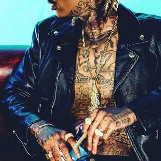 Wiz Khalifa- głównie napisy, liczby, symbole, litery. Przy szyi troche koloru, skrzydła i gwiazda. Czarna skóra, dużo pierścieni, wisior i dredy