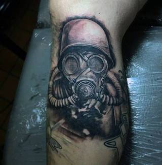 Żołnierz w masce gazowej wytatuowany na nodze.